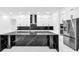 Bright kitchen with white cabinets, stainless steel appliances, black marble countertops, and a center island at 11921 Fort King Hwy, Thonotosassa, FL 33592