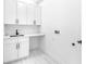 A clean laundry room with white cabinets and a sleek countertop sink at 11921 Fort King Hwy, Thonotosassa, FL 33592