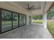Spacious covered patio with ceiling fan and sliding glass doors to backyard at 11921 Fort King Hwy, Thonotosassa, FL 33592