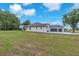 Rear exterior view of home with two-car garage on a sprawling green lot at 11921 Fort King Hwy, Thonotosassa, FL 33592