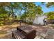 Spacious backyard with a brick patio, picnic table, and lush landscaping providing ample shade at 1216 E Lambright St, Tampa, FL 33604