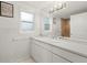 Well-lit bathroom with white cabinets and countertops, framed windows, and a framed mirror at 1216 E Lambright St, Tampa, FL 33604