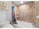Bathroom with decorative shelves, a bathtub, and shower, and a modern low-flow toilet at 1216 E Lambright St, Tampa, FL 33604