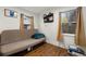 Comfortable guest bedroom with hardwood flooring, a futon, and two windows providing natural light at 1216 E Lambright St, Tampa, FL 33604