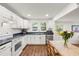Well-lit kitchen features white cabinetry, stainless steel appliances, and wood grain floors at 1216 E Lambright St, Tampa, FL 33604