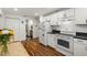 Renovated eat-in kitchen with white cabinets, modern appliances, and wood-look flooring at 1216 E Lambright St, Tampa, FL 33604