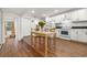 Eat-in kitchen boasts an open layout, modern appliances, white cabinets, and laminate flooring at 1216 E Lambright St, Tampa, FL 33604