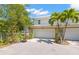 Two-story home featuring a two-car garage, verdant landscaping, and a basketball hoop in the driveway at 1271 Drew St, Clearwater, FL 33755