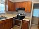 Functional kitchen featuring stainless steel appliances and wood cabinetry for storage at 12720 Jan St, San Antonio, FL 33576