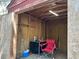 The shed has plywood walls, a red chair, a desk, a florescent light, and room to pursue your hobby at 12720 Jan St, San Antonio, FL 33576