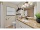 Well-lit bathroom featuring a granite vanity, white cabinetry and modern fixtures at 1322 Byron Dr, Clearwater, FL 33756