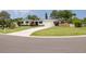 Well-maintained single-story home with a white exterior, manicured lawn, and mature landscaping at 1322 Byron Dr, Clearwater, FL 33756