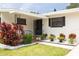 Inviting front porch with well-kept landscaping, decorative plants, and an iron railing at 1322 Byron Dr, Clearwater, FL 33756