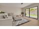 Comfortable living room with neutral tones, stylish rug, and sliding glass doors to the backyard at 1322 Byron Dr, Clearwater, FL 33756