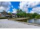 Exterior of lakeside apartments with sandy beach area and mature trees adding shade at 1400 Gandy N Blvd # 1705, St Petersburg, FL 33702