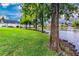 Lush green backyard with mature trees next to a pond, creating a tranquil outdoor space at 1400 Gandy N Blvd # 1705, St Petersburg, FL 33702