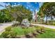 Community entrance with well-maintained landscaping, signage, and an American flag at 1400 Gandy N Blvd # 1705, St Petersburg, FL 33702