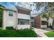 View of multi-story condo complex with screened-in patios, grey siding, brick accents, and mature landscaping at 1400 Gandy N Blvd # 1705, St Petersburg, FL 33702