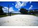 Outdoor sand volleyball court with a well-maintained net, and a clear blue sky with puffy white clouds at 1400 Gandy N Blvd # 1705, St Petersburg, FL 33702