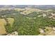 An aerial shot reveals the property's lush woodland, open meadows, adjacent houses, and a neighboring Bedroom at 14409 Curley Rd, Dade City, FL 33525