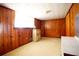 Finished basement with wood paneling and wall-to-wall carpeting offers a cozy space at 14409 Curley Rd, Dade City, FL 33525