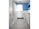 Functional bathroom featuring white tile walls, black and white floor tiles, and vintage fixtures at 14409 Curley Rd, Dade City, FL 33525
