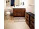 Bathroom with a vanity with dark wood cabinets, a toilet and decorative wall mirror at 14409 Curley Rd, Dade City, FL 33525