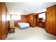 Finished basement bedroom featuring wood paneling and carpeting offers a cozy space at 14409 Curley Rd, Dade City, FL 33525