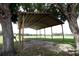 Open carport with metal roof and wooden supports, offering ample space in a lush green setting at 14409 Curley Rd, Dade City, FL 33525
