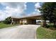 Exterior view of home showing long driveway, attached carport, and landscaped lawn at 14409 Curley Rd, Dade City, FL 33525
