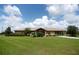 Inviting single-story home with a metal roof and porte cochere, set on a large lot with mature landscaping at 14409 Curley Rd, Dade City, FL 33525