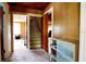 Hallway with wood paneling and carpet flooring providing access to multiple rooms in the home at 14409 Curley Rd, Dade City, FL 33525