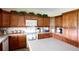 Close up view of the spacious kitchen with wood cabinets and white appliances at 14409 Curley Rd, Dade City, FL 33525
