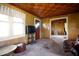Retro living room with wood paneling, checkered ceiling, and ample natural light through large windows at 14409 Curley Rd, Dade City, FL 33525