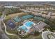 Aerial view featuring the community pool, tennis courts, and clubhouse with well-maintained landscaping at 14634 Mirasol Manor Ct, Tampa, FL 33626