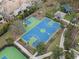 Aerial view of a green and blue basketball court with playground in the background on a sunny day at 14634 Mirasol Manor Ct, Tampa, FL 33626