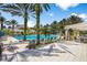 Resort-style community pool with palm trees, lounge chairs, and a clubhouse in the background, perfect for relaxation at 14634 Mirasol Manor Ct, Tampa, FL 33626