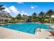 Spacious community pool featuring clear blue water, palm trees, a slide, and ample deck space for residents' enjoyment at 14634 Mirasol Manor Ct, Tampa, FL 33626