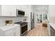 Modern kitchen features white cabinets, stainless steel appliances, and hardwood flooring at 14634 Mirasol Manor Ct, Tampa, FL 33626