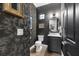 Stylish powder room with dark floral wallpaper, a round mirror, and gold accents for a luxurious feel at 1570 Marinella Dr, Palm Harbor, FL 34683