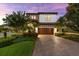 Stunning two-story home with a paver driveway and lush landscaping at 1570 Marinella Dr, Palm Harbor, FL 34683