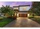 Beautiful two-story home featuring a paver driveway and meticulously maintained landscaping at 1570 Marinella Dr, Palm Harbor, FL 34683