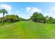 Scenic view of the lush green golf course on a sunny day with trees and blue skies at 1570 Marinella Dr, Palm Harbor, FL 34683