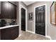 Hallway featuring dark cabinets, wood-style tile flooring, and multiple doorways for a modern touch at 1570 Marinella Dr, Palm Harbor, FL 34683