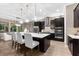 Modern kitchen with dark cabinets, stainless steel appliances, and a center island with chairs and pendant lights at 1570 Marinella Dr, Palm Harbor, FL 34683