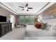Bright main bedroom with a ceiling fan, large windows, and a dark wood dresser at 1570 Marinella Dr, Palm Harbor, FL 34683