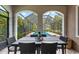 A charming outdoor dining area overlooks the screened-in pool and backyard at 1570 Marinella Dr, Palm Harbor, FL 34683