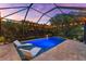 Beautiful screened pool with poolside lighting and elegant chaise lounges for ultimate relaxation at 1570 Marinella Dr, Palm Harbor, FL 34683