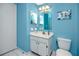 Bright blue bathroom with a white vanity and matching toilet at 16011 Saddle Creek Dr, Tampa, FL 33618