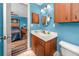 A bathroom with wood cabinets, a large mirror, and an open door to a bedroom at 16011 Saddle Creek Dr, Tampa, FL 33618